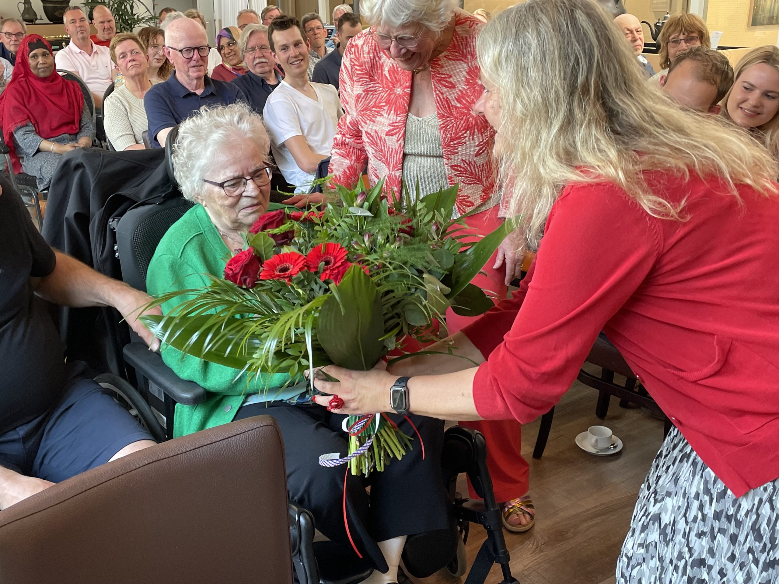 Esther-Mirjam Sent overhandigt een bos bloemen aan een jubilaris van de PvdA